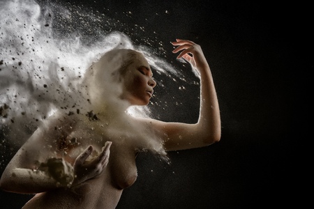 Girl topless in a cloud of white dust studio portraitの写真素材