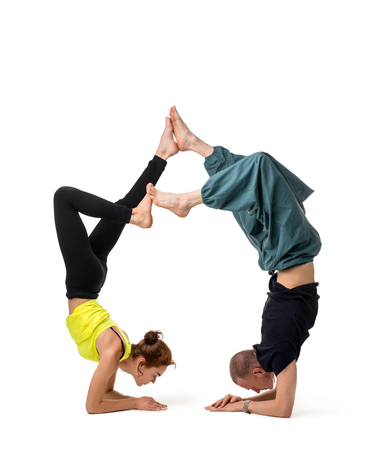 Two girls doing yoga together isolated on white