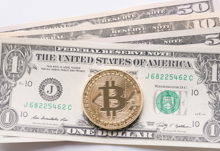 Golden bitcoin on dollars close up shotの写真素材
