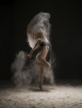 Slim girl wearing only a top in a dust cloud viewの写真素材