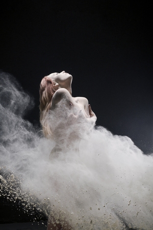 Nude red-haired girl shot in white dust cloudの写真素材