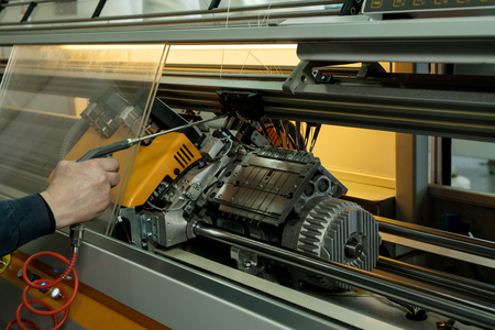 Serviceman setting up the knitting machine shot