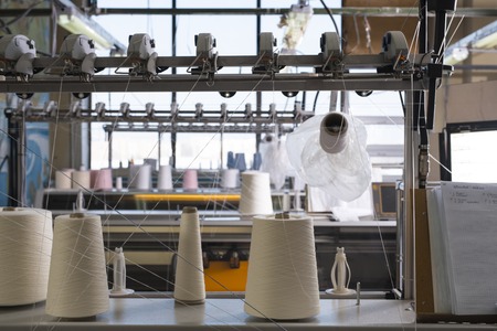 Spools with thread at rewinding machineの写真素材