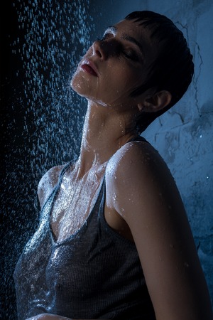 Beautiful brunette in gray t-shirt having showerの写真素材