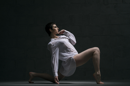Brunette in sexy shirt dancing in the dark shotの写真素材