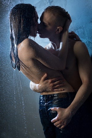 Naked couple kissing in a shower in the darkの写真素材