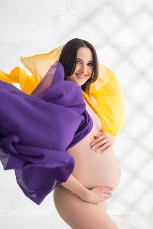 Happy pregnant woman shot in the nudeの写真素材