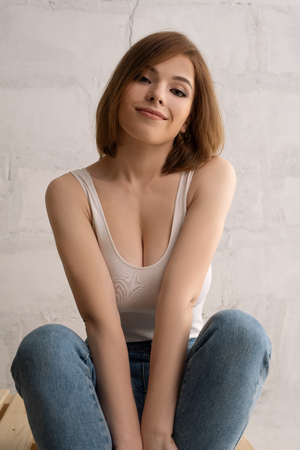 Young brunette smiling shot against brick wallの写真素材