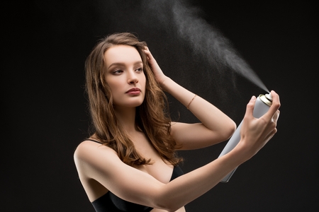 Young brunette in bra with hair spray shotの写真素材