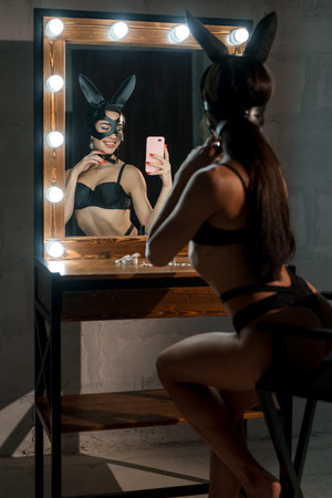 Woman in lingerie and bunny ears making selfieの写真素材