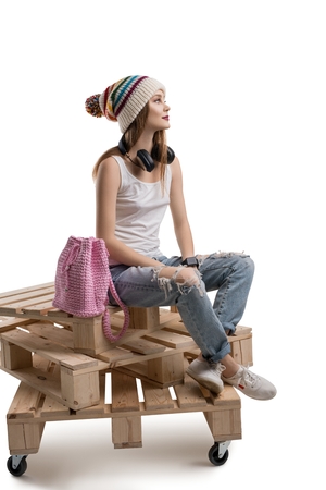 Trendy woman sitting on wooden palletsの写真素材