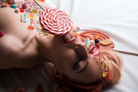 Blonde with sweets and caramel on her face shotの写真素材