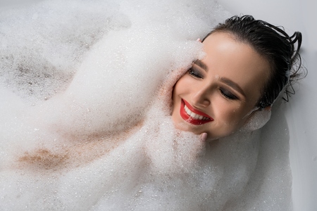 Happy brunette having bath high angle viewの写真素材