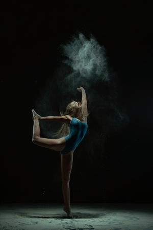 Graceful blonde dancing in dust cloud profile viewの写真素材