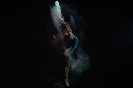 Graceful girl dancing in dust cloud profile viewの写真素材