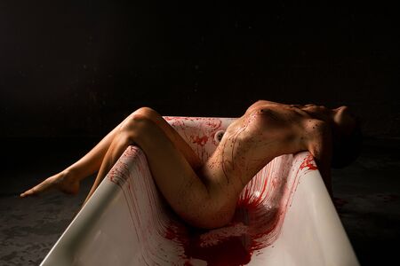 Nude brunette bleeding in bath shot