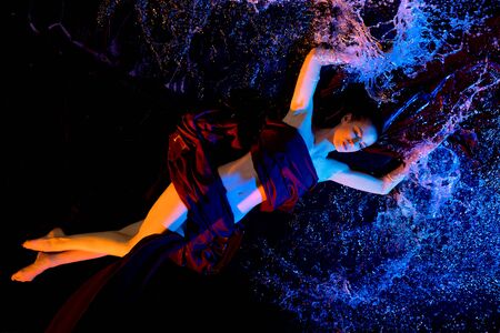 Nude girl lying in water in the darkの写真素材