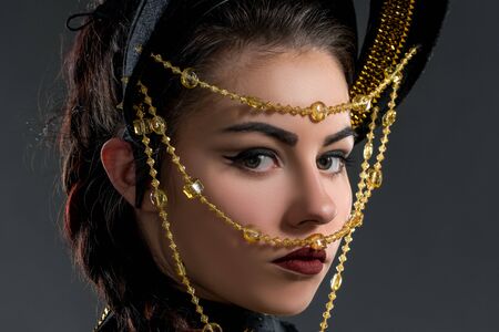 Portrait of pretty dancer in headdress with beads