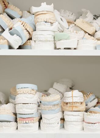 Piles of dentures on several shelves close up shot