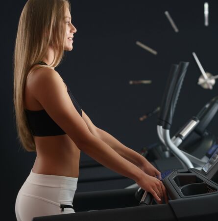 Sports concept. Girl trains on background of clock