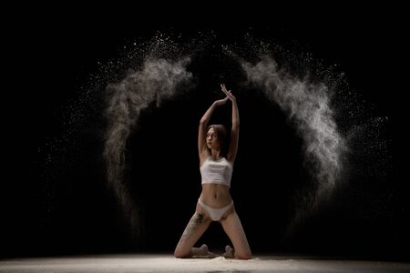 Slim girl in lingerie in white dust cloud shotの写真素材