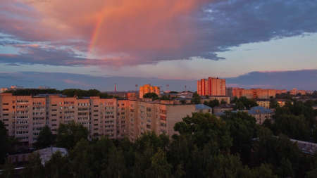 Rainbow over city in summer eveningの写真素材