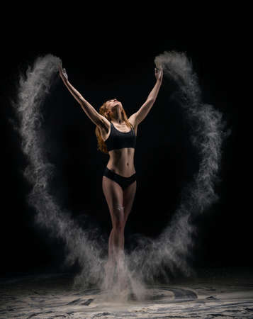 Slim female dancer throwing dust in airの写真素材