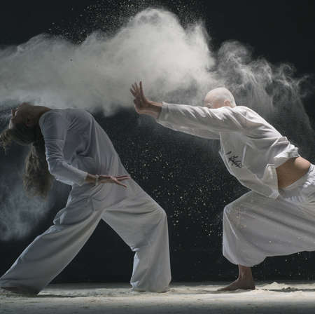 Two men doing yoga in white dust cloud view