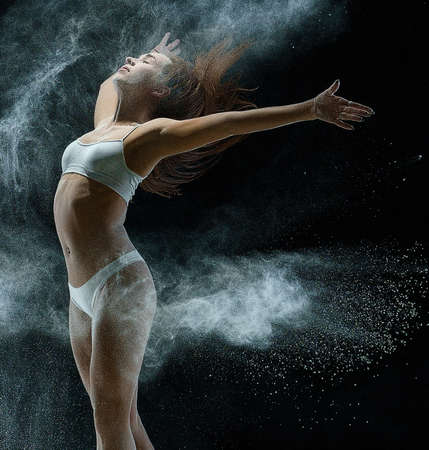 Girl in a cloud of white dust studio portraitの写真素材