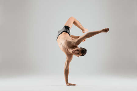 Flexible man dancing breakdance on one hand
