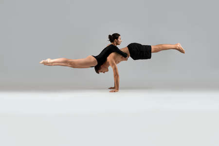 Couple in sportswear doing balance exercise on hands
