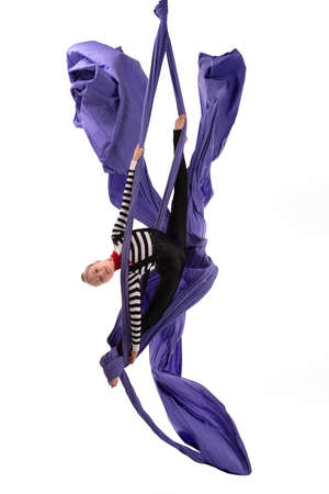 Flexible girl doing aerial silks trick on fabricの写真素材