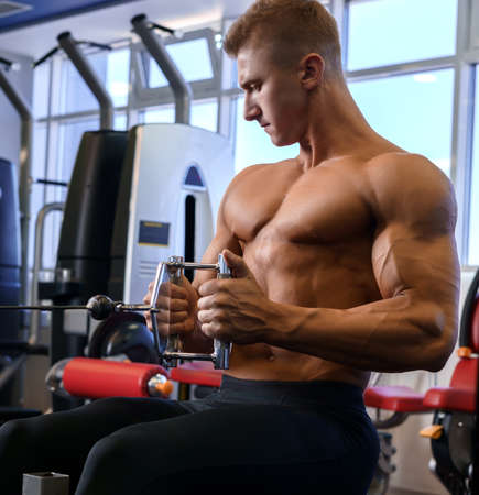 Male athlet doing sports exercises gym shot