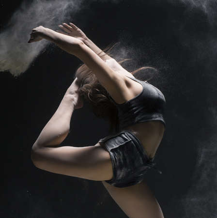 Woman in sportswear jumping in dust cloud viewの写真素材