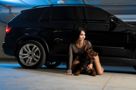 Smiling woman with dog near carの写真素材