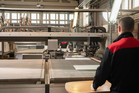Unrecognizable man working on industrial machine in factoryの写真素材
