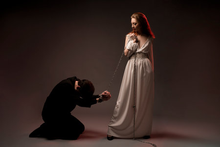 Man with tied hands kneeling near womanの写真素材