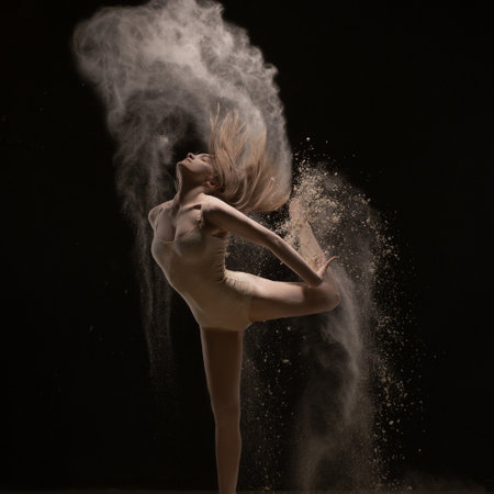 Woman dancing gracefully in white dust cloudの写真素材