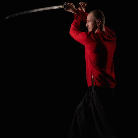 Male in red shirt doing exercises with a swordの写真素材
