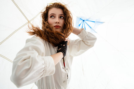 Woman With Red Hair Posing Under a Blue Umbrella