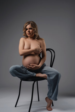 Pregnant Woman Sitting on Chair in Studioの写真素材