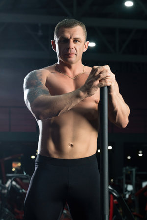 Tattooed shirtless male athlet shot in sports gymの写真素材