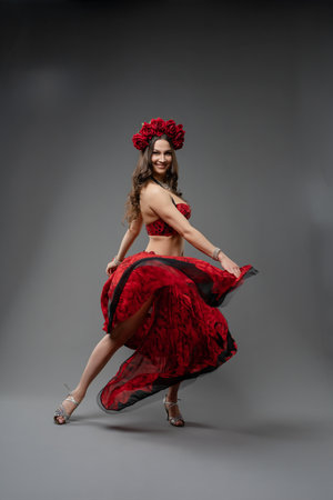 Dancer in vibrant red dress twirling gracefully with floral headpieceの写真素材