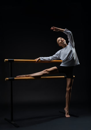 Graceful girl performing ballet at a dance studio during a nighttime classの写真素材