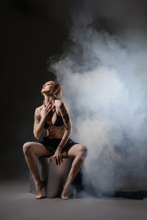 Artistic portrait of a woman in a smoky atmosphere during a studio sessionの写真素材