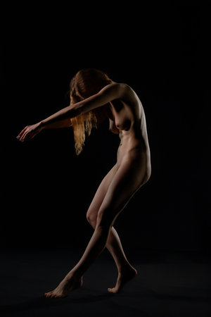 Elegant dance movement in soft light against a dark backgroundの写真素材