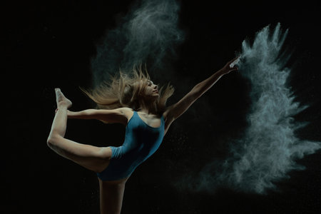 Dancer showcases grace and strength with athletic pose and powder effectの写真素材