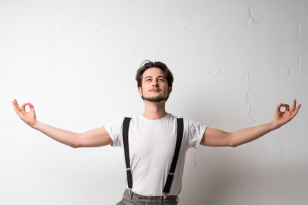 Man practicing mindfulness in a relaxed pose against a white backgroundの写真素材