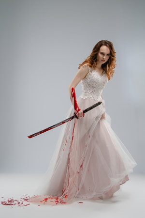 Bride in lingerie holds a katana on a soft backgroundの写真素材