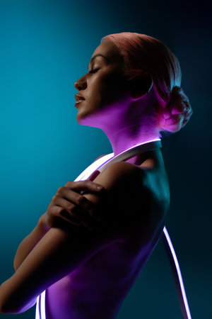 Elegant woman poses with soft lighting and neon accents in a serene atmosphereの写真素材
